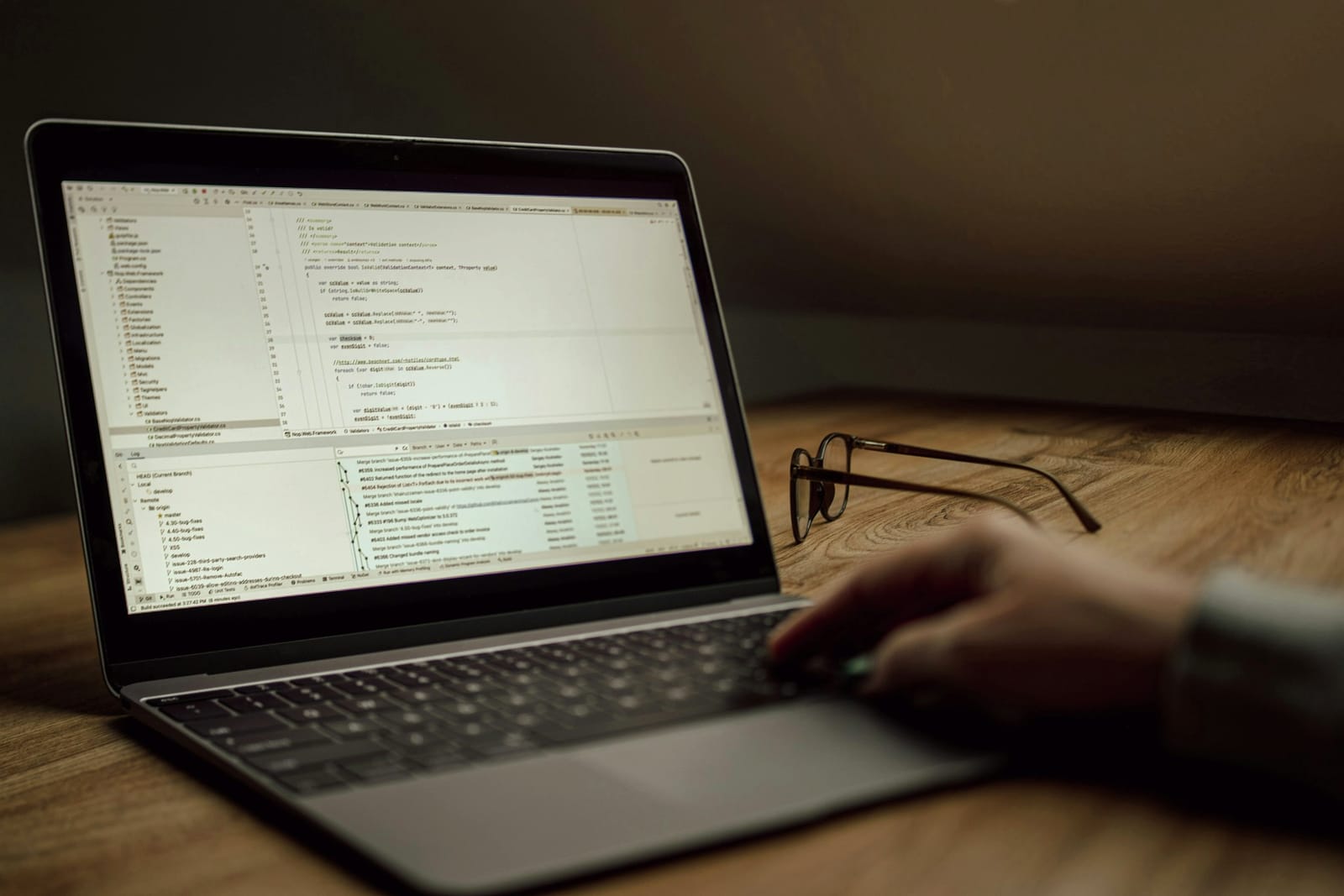 AI integration - service overview Developer working on application source code on a laptop in a dimly lit office